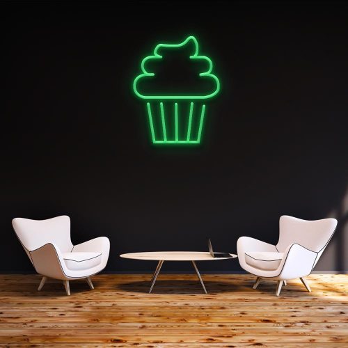 Green cake LED neon sign mounted on a dark wall, featured in a modern room setting with white chairs and wooden flooring, ideal for stylish home or cafe decor.