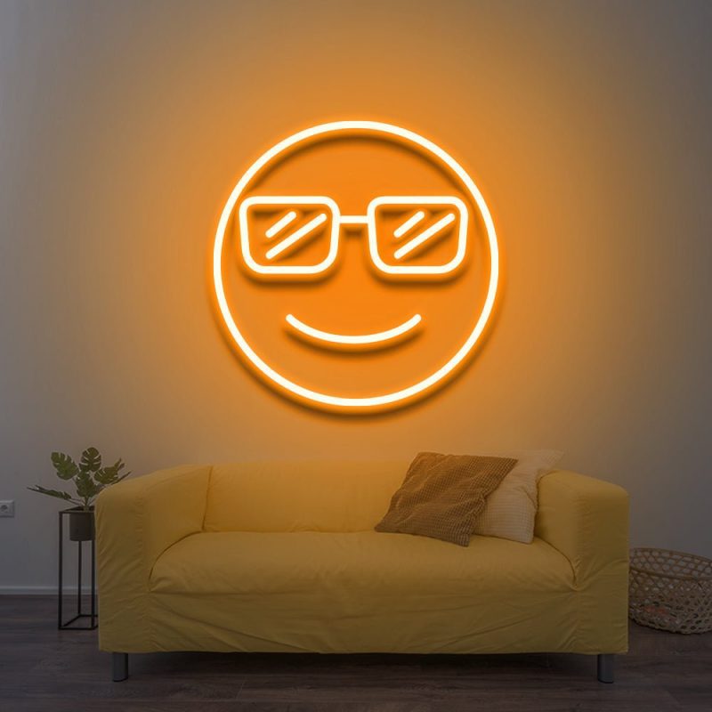 Cool LED Neon Sign featuring a smiling face with sunglasses, glowing yellow above a yellow couch, adding vibrant and fun decor to the room.