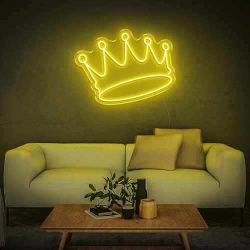 Yellow crown LED neon sign above sofa in a cozy living room with modern furniture.