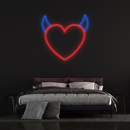 Red neon heart with blue devil horns displayed above a modern bed on a black wall, perfect for unique bedroom wall decor or themed spaces.